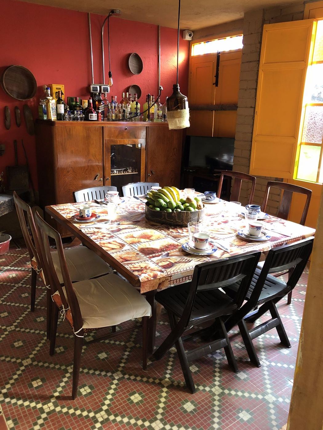 Comedor de la casa con mesa servida, bar y pared roja