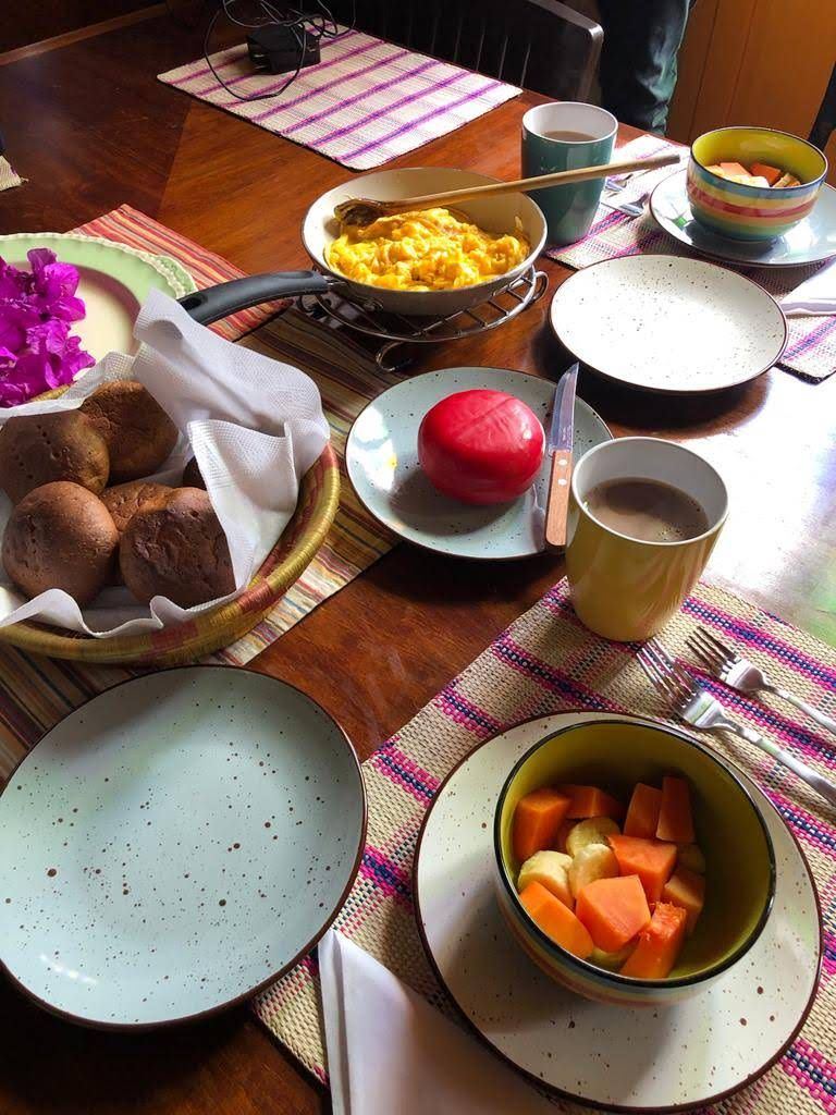 Desayuno con huevos, fruta, queso y chocolate caliente