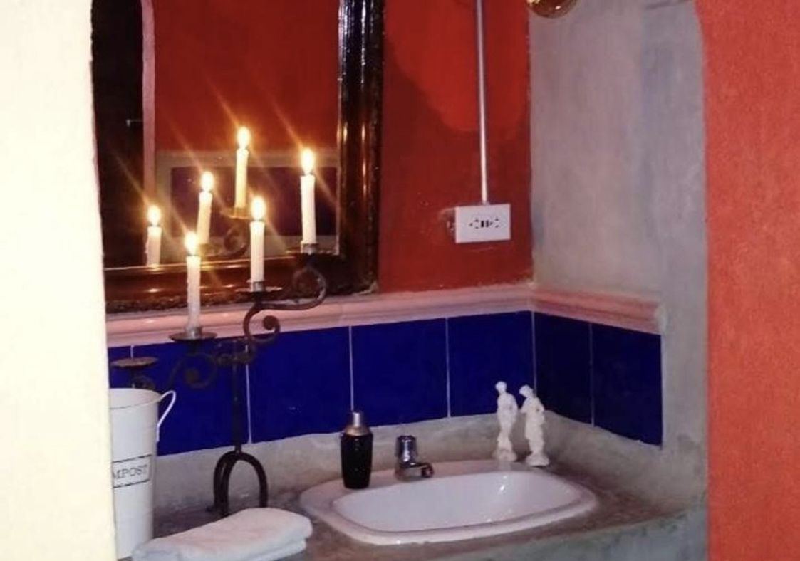 Baño de La Campesina con baldosa azul y velas