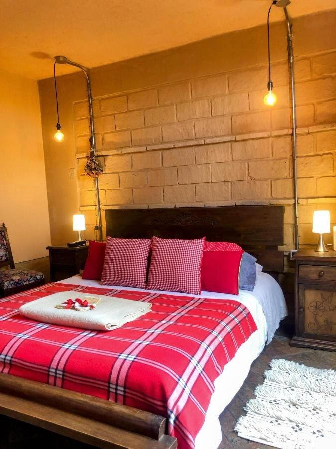 Cama Queen de La Rústica bajo las lámparas colgantes