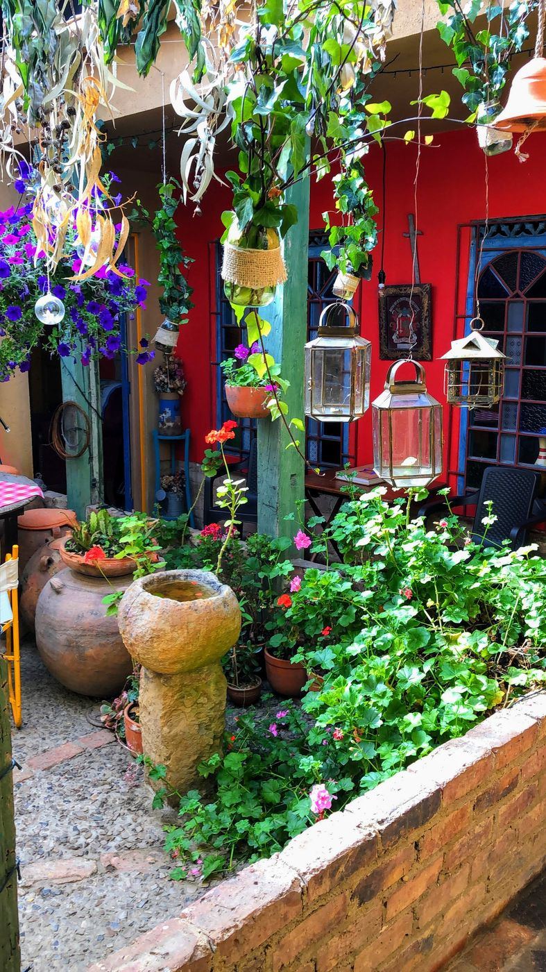Jardín del patio con ollas de barro y faroles