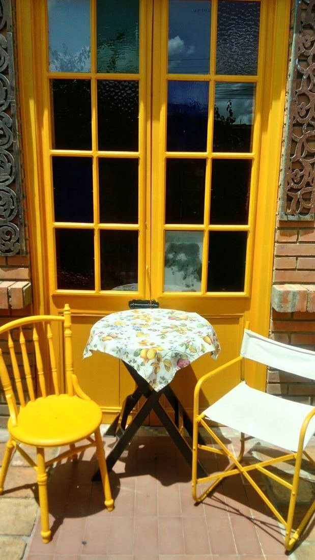 Puerta amarilla y sillas en la terraza