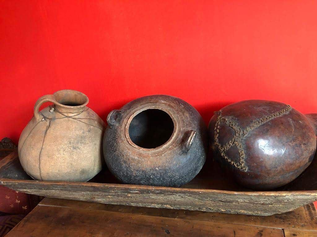 Vasijas de barro sobre la pared roja